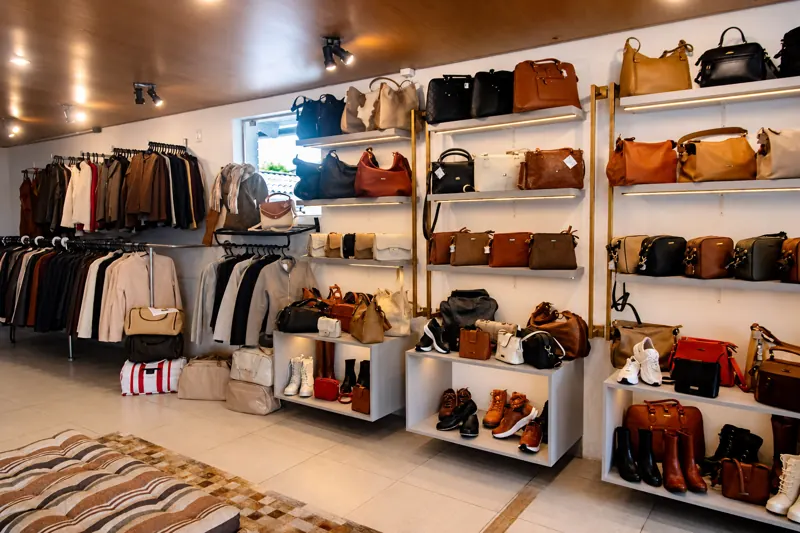 Prateleiras com bolsas, botas e jaquetas de couro